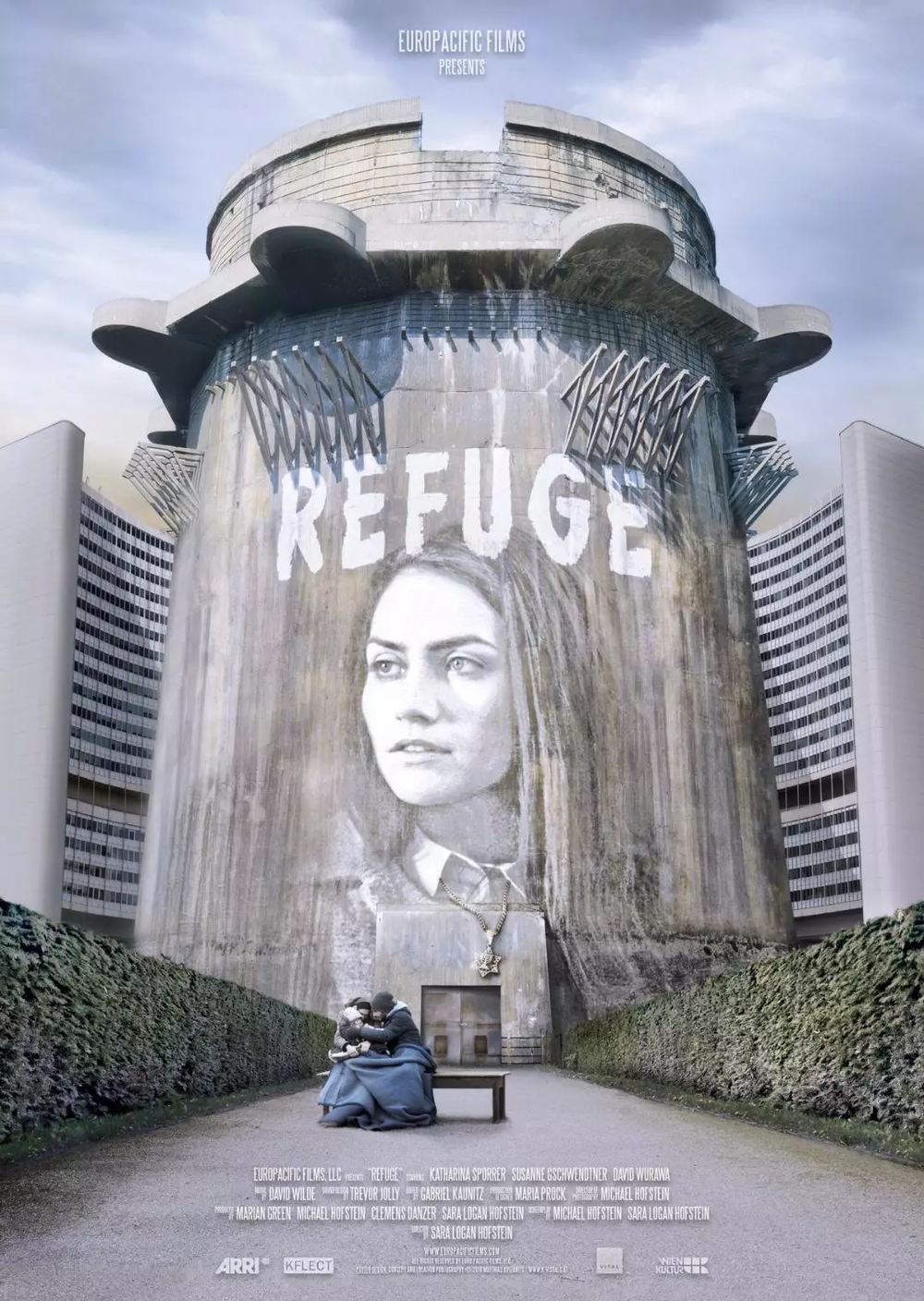 Poster for the film: Main character Rachel is superimposed on a flak tower, wearing a necklace with a star of David on it. In front of the tower, a refugee family with a small child sits on a bench draped in winter coats and blankets.